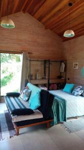 ein Schlafzimmer mit einem Bett und einem Sofa in einem Zimmer in der Unterkunft Sonho na Serra Chalé 2 in Gonçalves