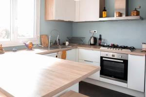 a kitchen with white cabinets and a stove top oven at Large cosy cocoon - downtown on foot in Cenon