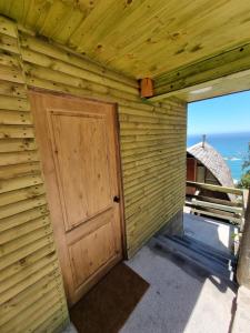 une porte sur le côté d'un bâtiment en bois dans l'établissement Cabañas Al Mar, à Viña del Mar