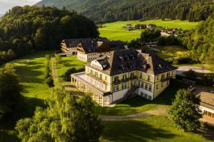 an aerial view of a mansion on a golf course at Arabella Jagdhof Resort am Fuschlsee, a Tribute Portfolio Hotel in Hof bei Salzburg