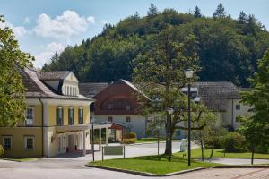 a group of buildings with a mountain in the background at Arabella Jagdhof Resort am Fuschlsee, a Tribute Portfolio Hotel in Hof bei Salzburg