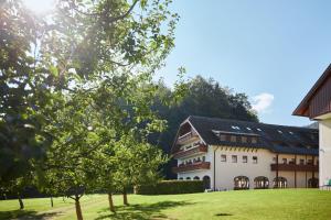 a large white building with a black roof at Arabella Jagdhof Resort am Fuschlsee, a Tribute Portfolio Hotel in Hof bei Salzburg