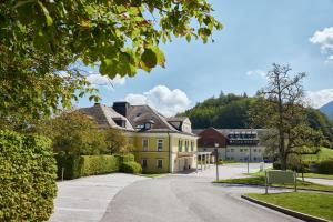 uma casa amarela no meio de uma rua em Arabella Jagdhof Resort am Fuschlsee, a Tribute Portfolio Hotel em Hof bei Salzburg