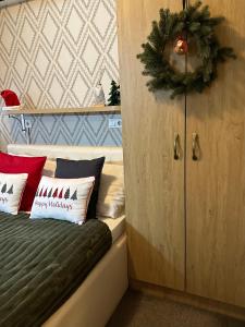 1 dormitorio con una corona de Navidad en una cama en Hotel Banja Luka, en Banja Luka