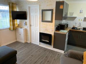 a living room with a fireplace in a kitchen at MaterMolly Hemsby Chalet Hire 240 Belle aire beach road Hemsby NR29 4HZ in Hemsby