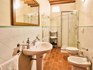 Un baño con lavabo, inodoro y espejo. en Serene Chianti Retreat, en Cavriglia 30 fotos más