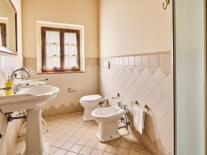 a bathroom with a toilet and a sink at Spacious apartment in villa with pool in Cavriglia