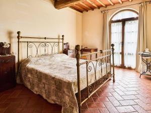 1 dormitorio con 1 cama de metal en una habitación en Beautiful farmhouse with swimming pool in Tuscany, en Cavriglia