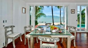 a dining room with a table and chairs and the ocean at Villa M in Bophut