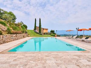 una piscina en una villa con sombrillas en Beautiful farmhouse with swimming pool in Tuscany, en Cavriglia