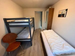 a small room with two bunk beds and a chair at Bungalow in Makkum near Lake Beach in Holle Poarte