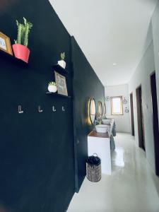 Clandestino Hostel Canggu في تشانغو: غرفة معيشة مع جدار أسود عليه نباتات