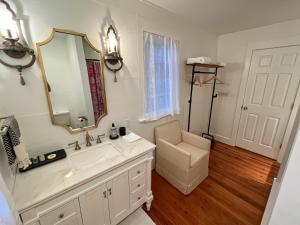 une salle de bain avec un lavabo, un miroir et une chaise dans l'établissement Cabana Madrid - Port Royal Luxury Rental Close Proximity to Parris Island and The Sands Beach, à Port Royal 32 autres photos