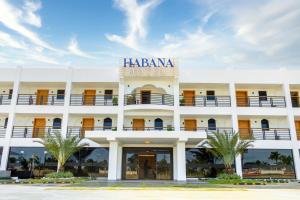 um grande edifício branco com uma placa que lê Hotel hacienda em Habana Hotel Y Restaurante em Higuey