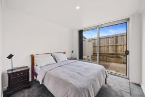 a bedroom with a bed and a large window at Petite Retreat in Cape Paterson