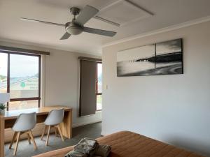 a living room with a ceiling fan and a table and chairs at Port Vincent Motel & Apartments in Port Vincent