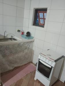 a small kitchen with a stove and a sink at kitnet sao thome das letras in São Thomé das Letras