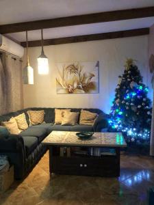 ein Wohnzimmer mit Sofa und Weihnachtsbaum in der Unterkunft Almagicama in Villa Serrana