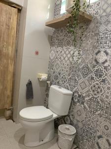 La salle de bains est pourvue de toilettes et d'un mur en carrelage. dans l'établissement Angel House Ubud Eco Villa, à Ubud