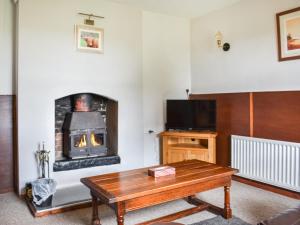 a living room with a fireplace and a coffee table at Cozy Cow Cottage in Belford