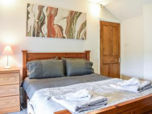 a bedroom with a bed with towels on it at Cozy Cow Cottage in Belford