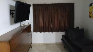 sala de estar con TV y tocador con ventana en Los Lirios en Sierra de los Padres