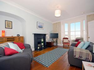 a living room with two couches and a fireplace at Ty Mair in Tenby