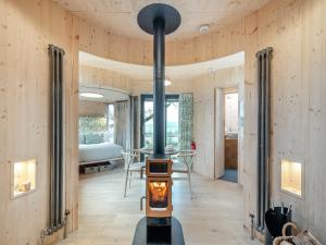 a wood burning stove in a room with a bedroom at The Treehouse Caerlaverock - Uk45028 in Carsethorn