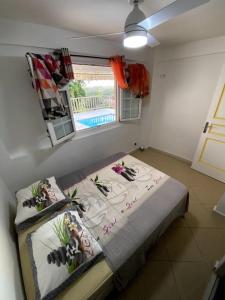 een kleine kamer met een bed en een raam bij Appartement T2 - vue campagne in Le Robert