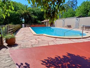 塞拉德洛斯帕德雷斯百合山林小屋的一个带围栏的院子内的一个大型游泳池