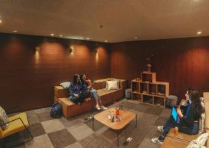 Viajero Bogota Hostel & Spa في بوغوتا: مجموعة من الناس يجلسون في غرفة المعيشة