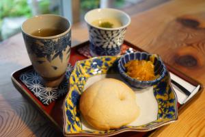 talerz jedzenia z dwoma filiżankami herbaty na stole w obiekcie TOSAYAMA BASE 清流沿いの里山　古民家貸切　高知市街地より車で約20分 w mieście Kochi