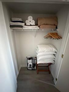 a small closet with a shelf with towels and a pillow at Relax & Rejuvenate at 2BR Retreat with Pool & Gym in Shanty Bay