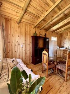 Habitación de madera con mesa, sillas y sofá en Cabaña en Vichuquén, Chile, en Vichuquén