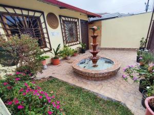 a fountain in the courtyard of a house with flowers at Aires frescos de Boquete in Alto Boquete