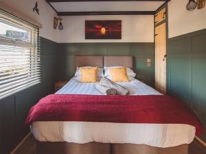 um quarto com uma cama grande e um cobertor vermelho em Cedar Lodge -uk44425 em Donyatt