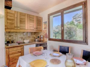 a kitchen with a table with chairs and a window at Appartement Corrençon-en-Vercors, 3 pièces, 6 personnes - FR-1-761-28 in Corrençon-en-Vercors