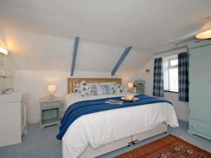 a bedroom with a large bed with blue and white sheets at Ty Gwyn Farmhouse in St. Davids