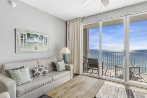 a living room with a couch and a large window at Majestic Sun Resort by Tufan in Destin