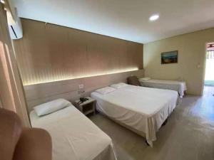 ein Hotelzimmer mit 2 Betten und 2 Tischen in der Unterkunft Resort Campo Belo in Álvares Machado
