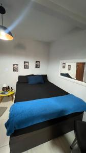 1 dormitorio con 1 cama grande con manta azul en Hospedagem Recanto da Praia Posto 12, en Río de Janeiro