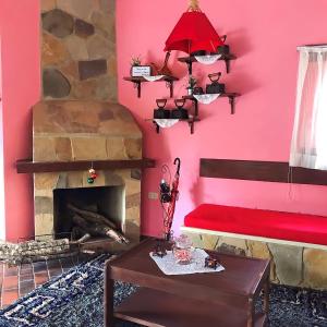 a living room with a fireplace and a red wall at Cabañas Lijeron Samaipata in Samaipata