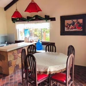 eine Küche mit einem Tisch, Stühlen und einer Theke in der Unterkunft Cabañas Lijeron Samaipata in Samaipata