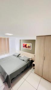 a bedroom with a bed and a painting on the wall at Flat Tambaú - Beira-mar in João Pessoa