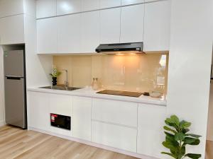 una cocina con armarios blancos y fregadero en Lu Homestay & Apartment, en Thôn Văn Dương