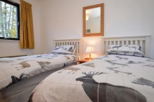 two beds sitting next to each other in a bedroom at Heronlea Cottage in Dunoon