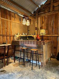 a kitchen with two stools and a bar in a room at COI NGUON FARM GLAM Mang Den in Kon Von Kla