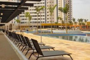 a row of chairs sitting next to a swimming pool at Suite Deluxe Enjoy Solar- 5 pessoas in Olímpia +2 photos