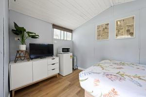 a bedroom with a bed and a flat screen tv at Bright Cabin Park in Bright