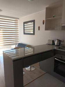 una cucina con piano di lavoro nero in una camera di Grato y nuevo departamento a Quilpué